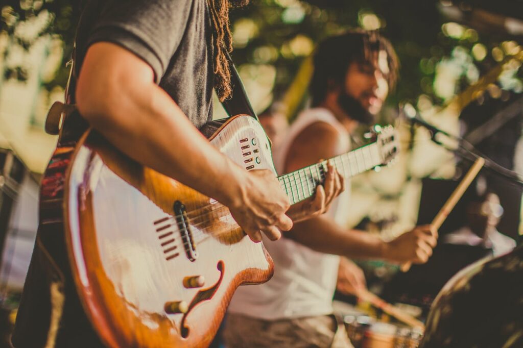 one man playing guitar and another playing the drums